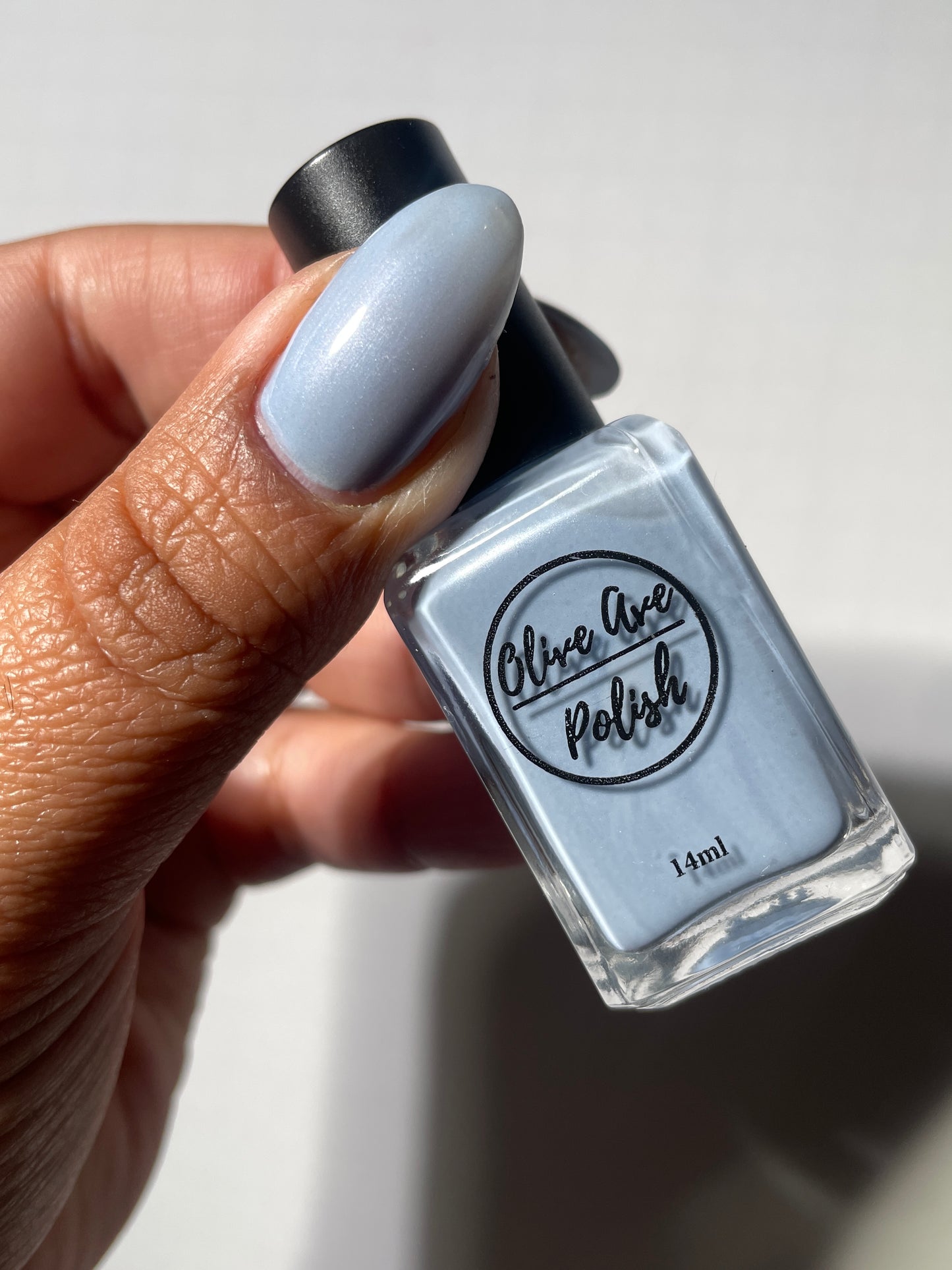 Pastel blue pearl nail polish on medium dark skin