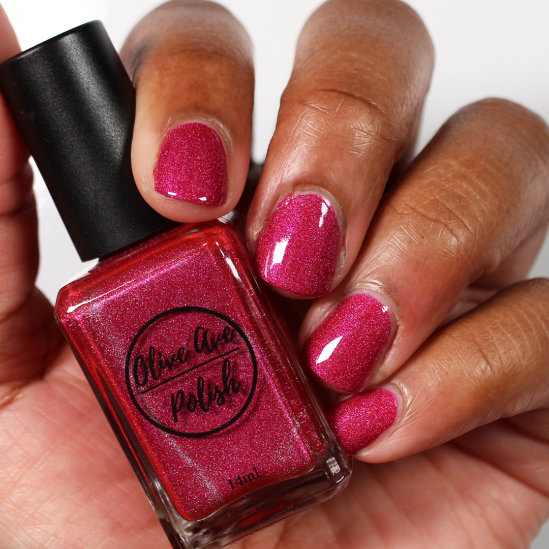 pink holographic nail polish swatch on medium skin tone