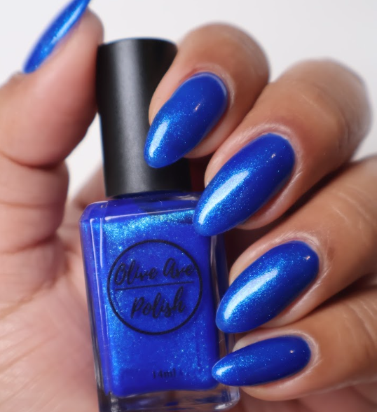 Blue glitter nail polish swatch on pale skin tone