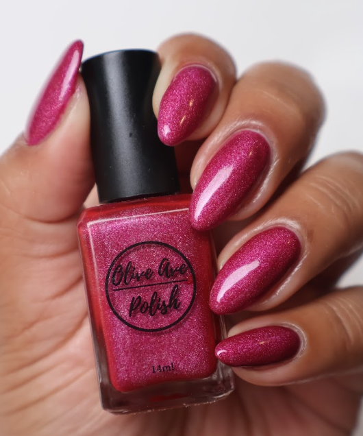 pink holographic nail polish swatch on medium skin tone