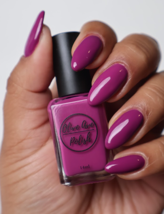 magenta nail polish swatch on medium dark skin tone