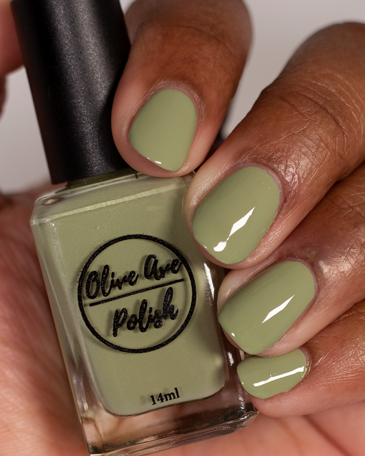 sage green nail polish swatch on medium skin tone