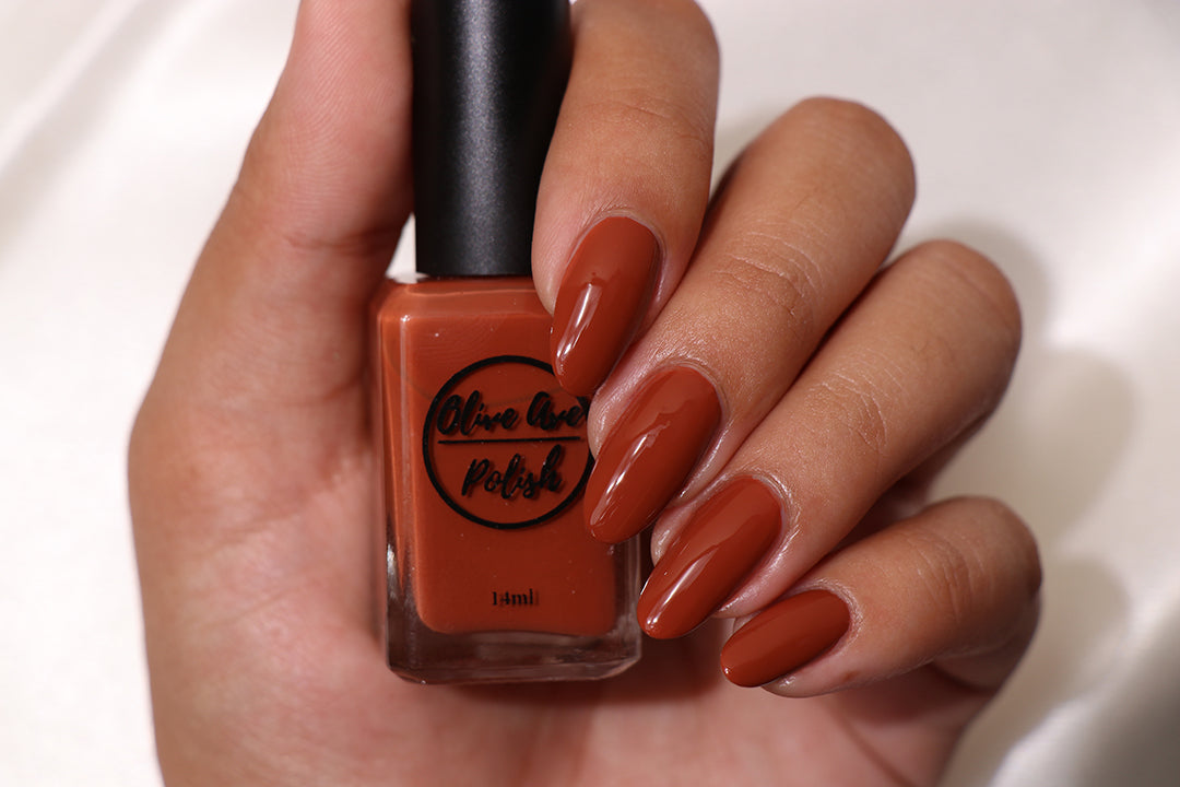 Fall orange nail polish swatch on medium skin tone