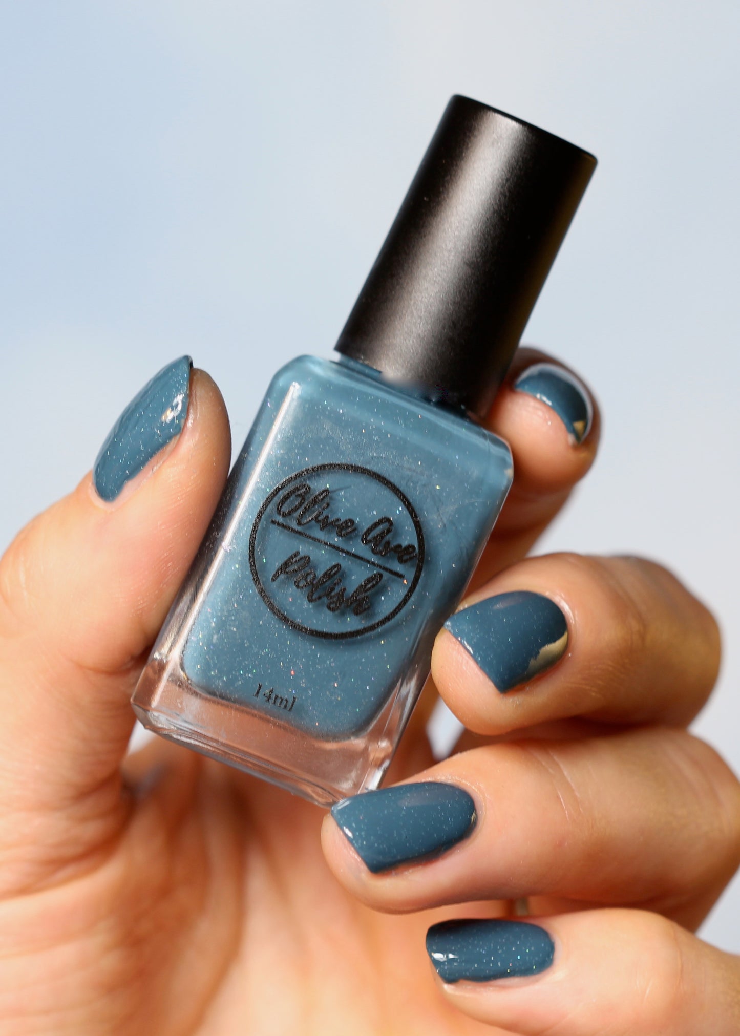 blue holographic nail polish swatch on pale skin tone