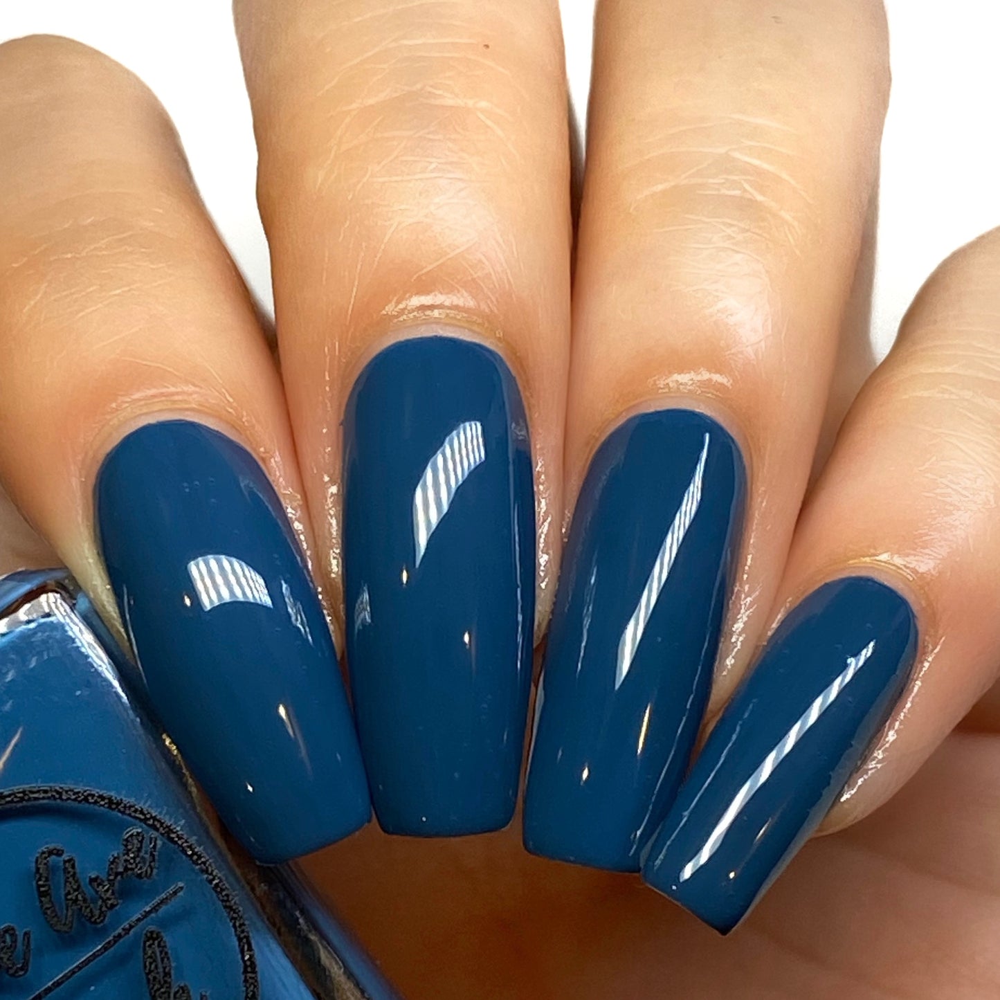 Peacock blue nail polish swatch on pale skin tone