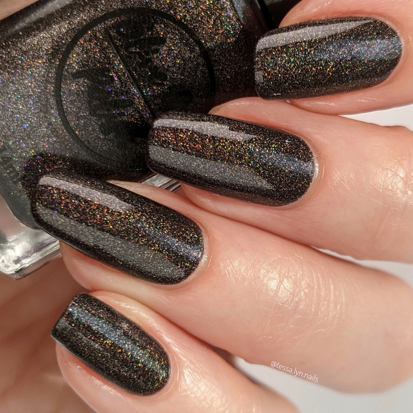 brown holographic nail polish swatch on pale skin tone