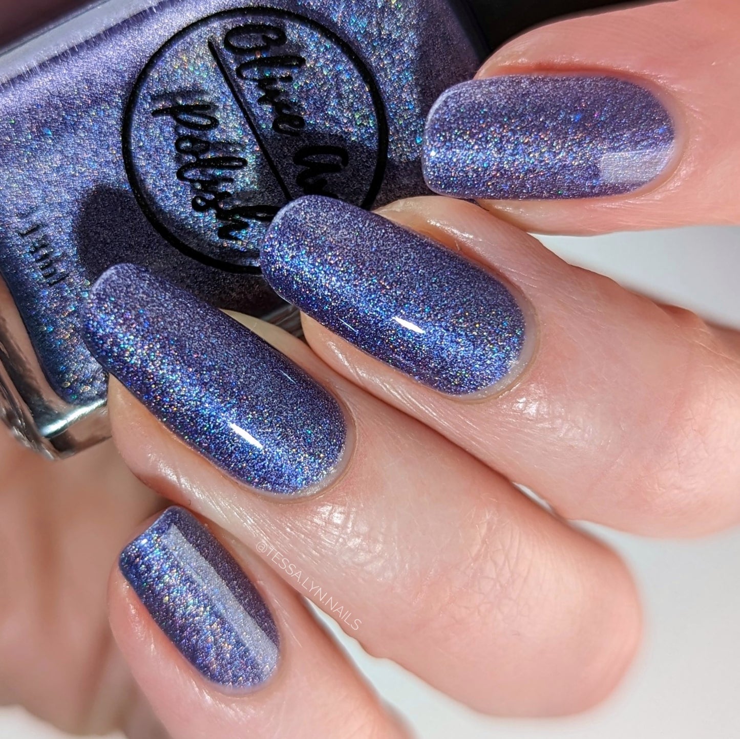 Purple holographic nail polish swatch on pale skin tone