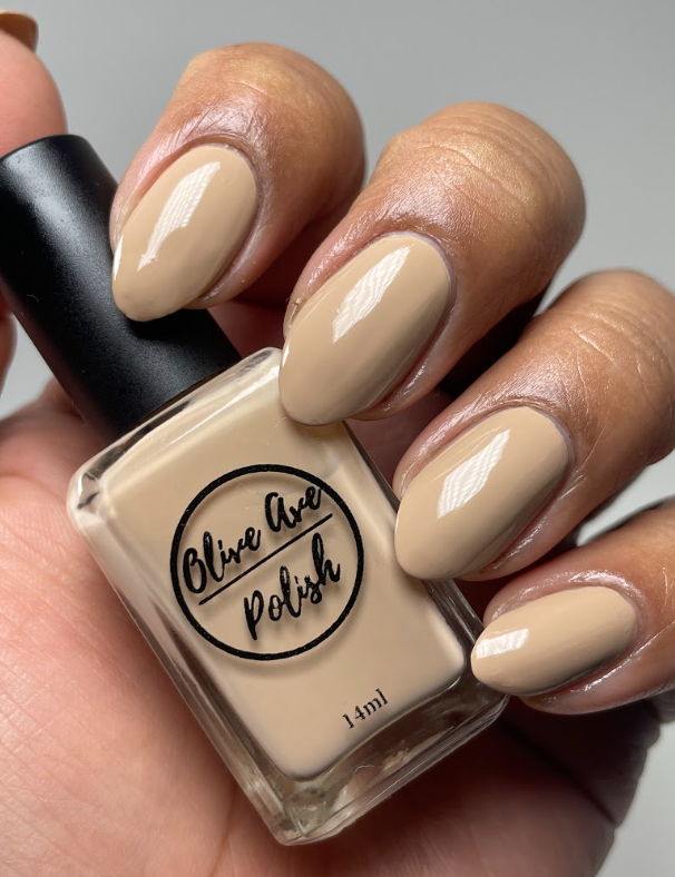 Tan nude nail polish swatch on medium skin tone