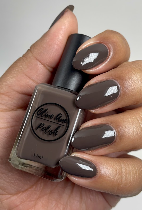 dark brown nail polish swatch on medium skin tone