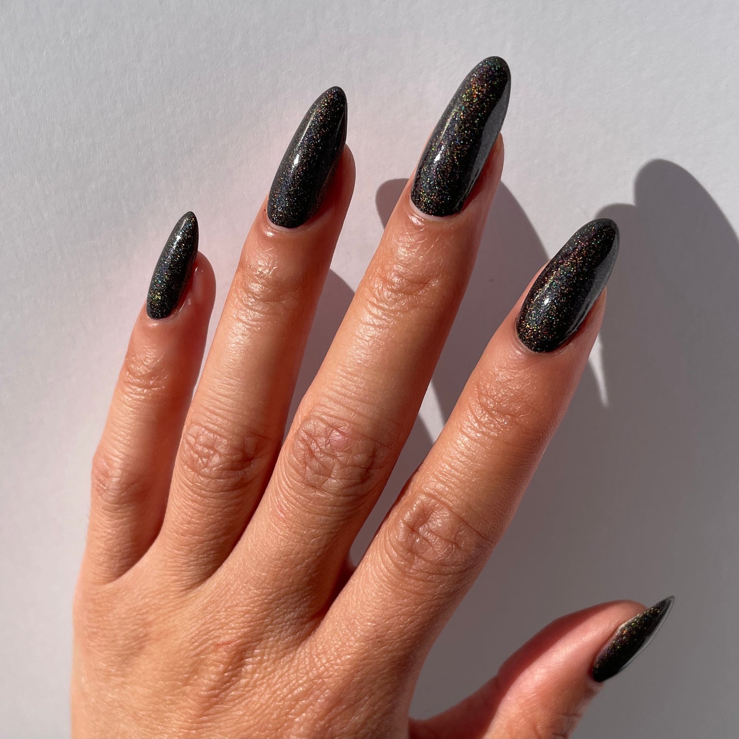 brown holographic nail polish swatch on pale skin tone