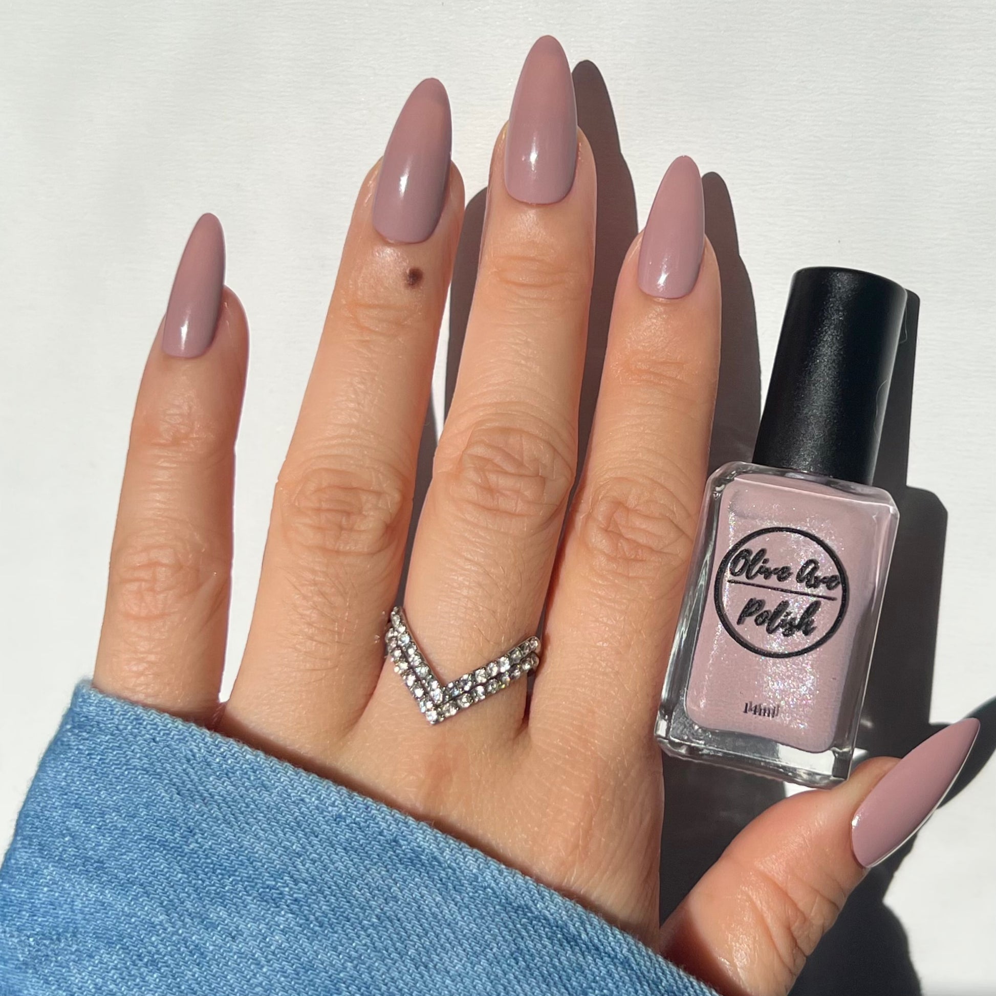 Shimmery taupe nail polish swatch on pale skin tone
