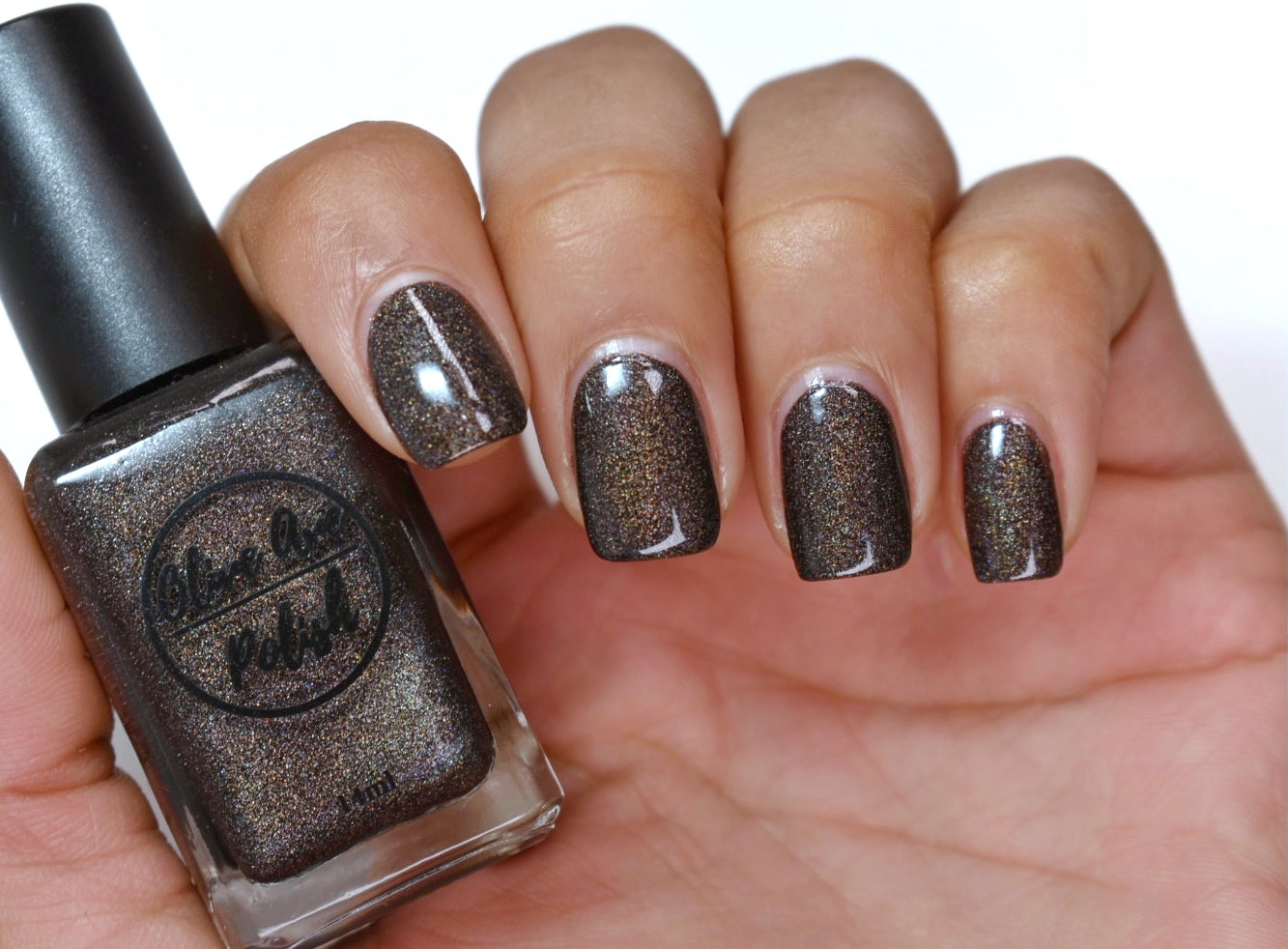 brown holographic nail polish swatch on pale skin tone