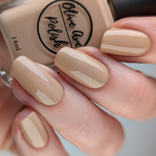 Tan nude nail polish swatch on pale skin tone