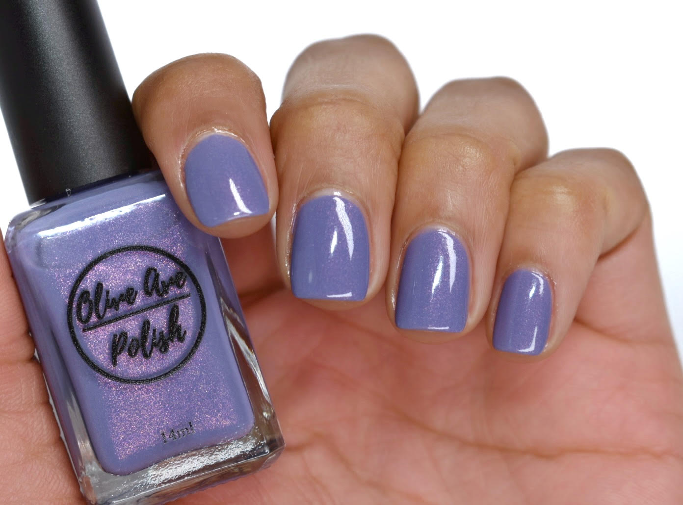 Purple shimmer nail polish swatch on medium skin tone