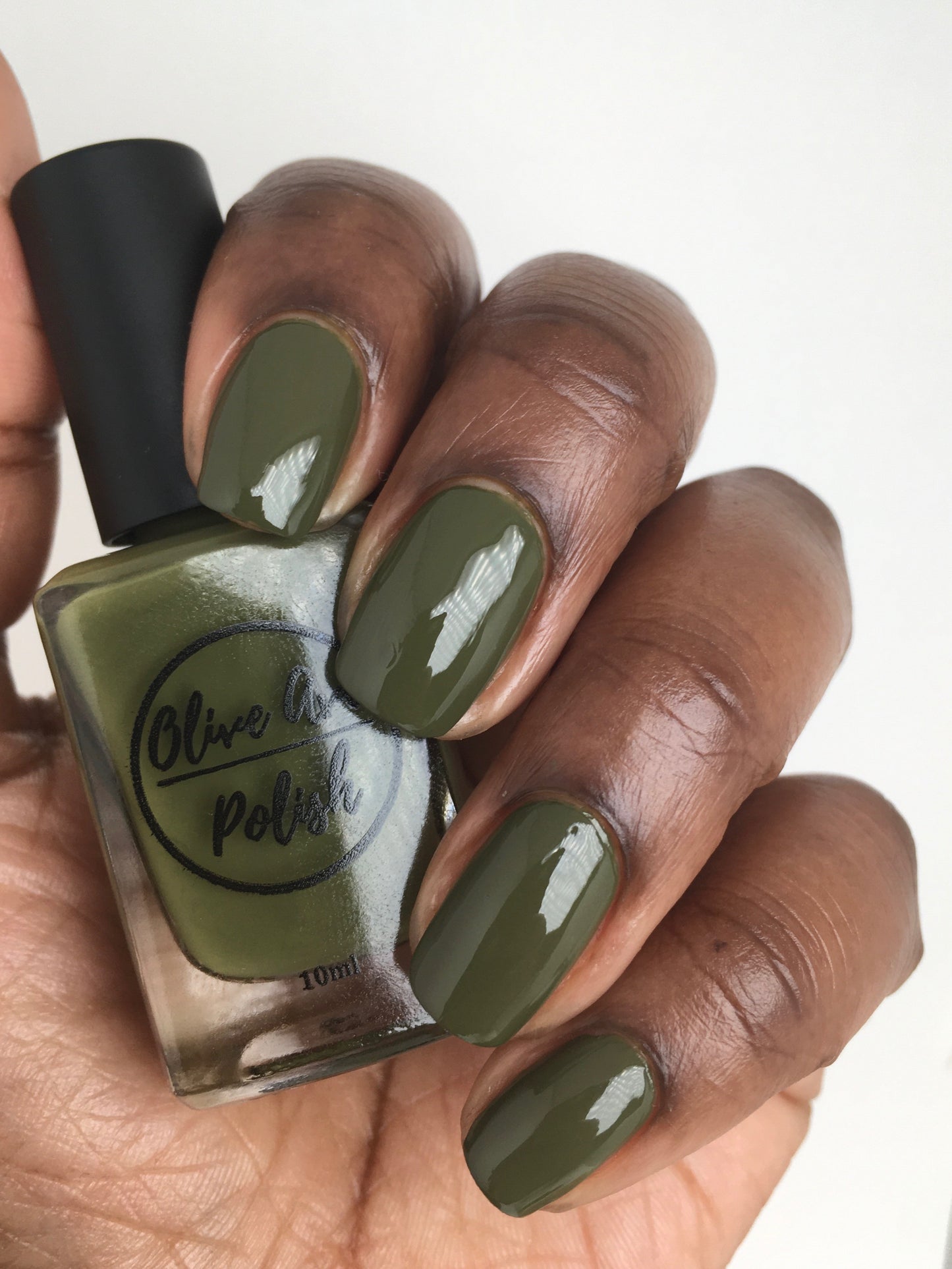 olive green nail polish swatch on medium deep skin tone
