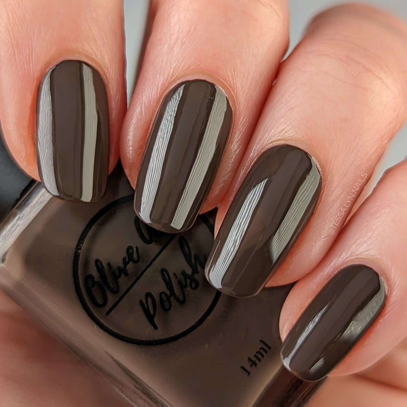 dark brown nail polish swatch on medium skin tone