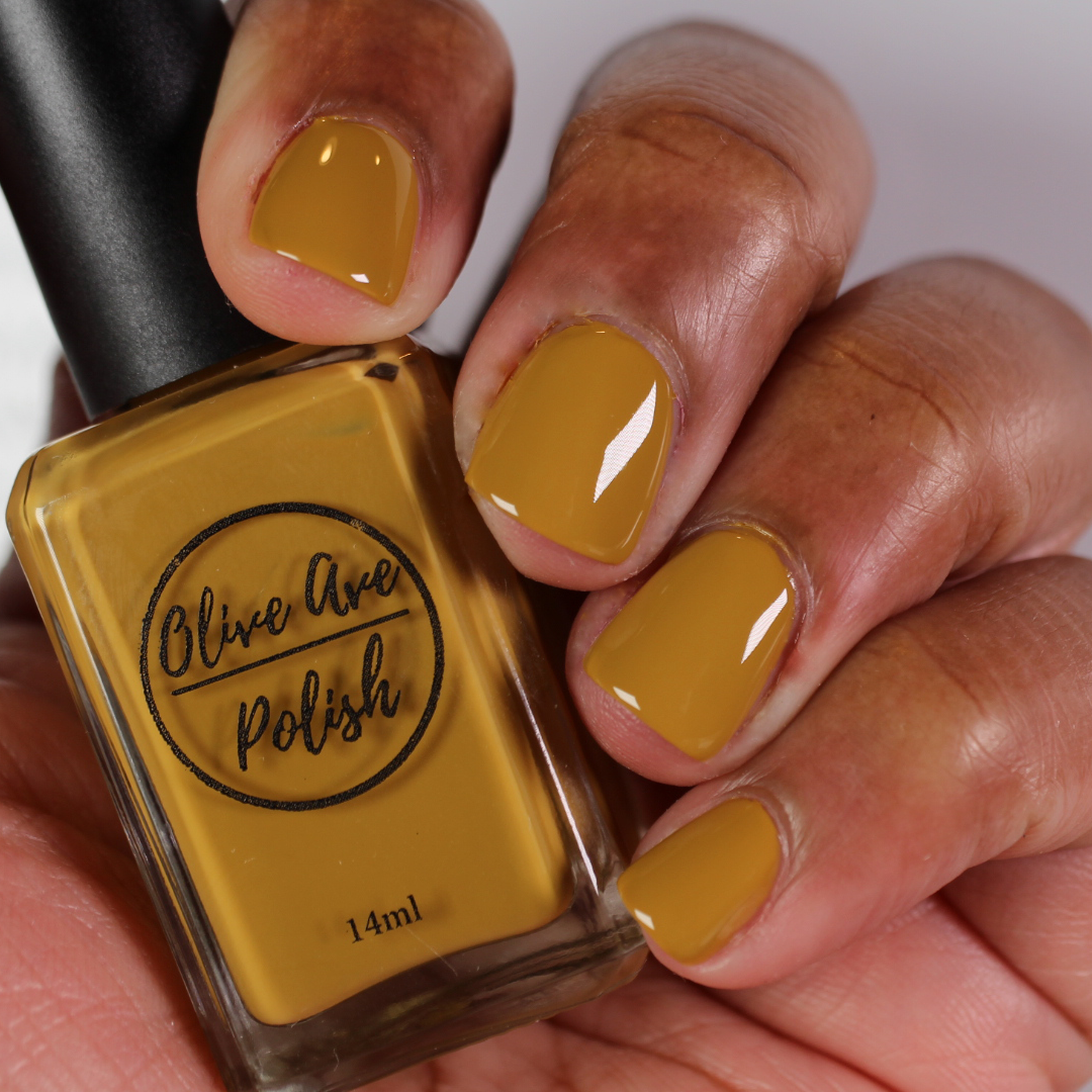 mustard yellow nail polish on dark skin tone