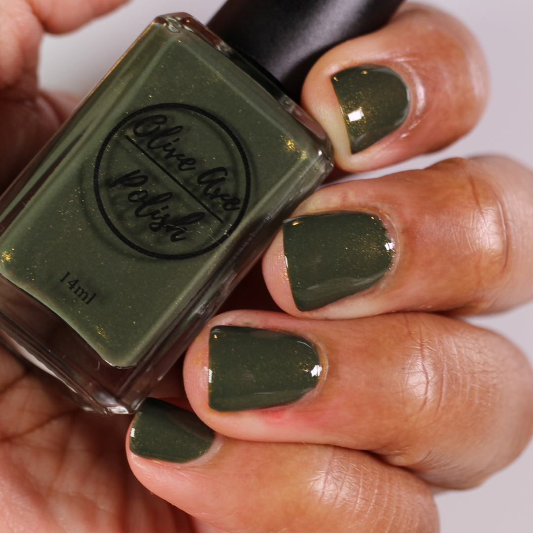 forest green nail polish with gold shimmer on dark skin tone