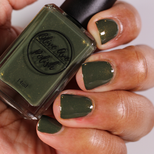 forest green nail polish with gold shimmer on dark skin tone