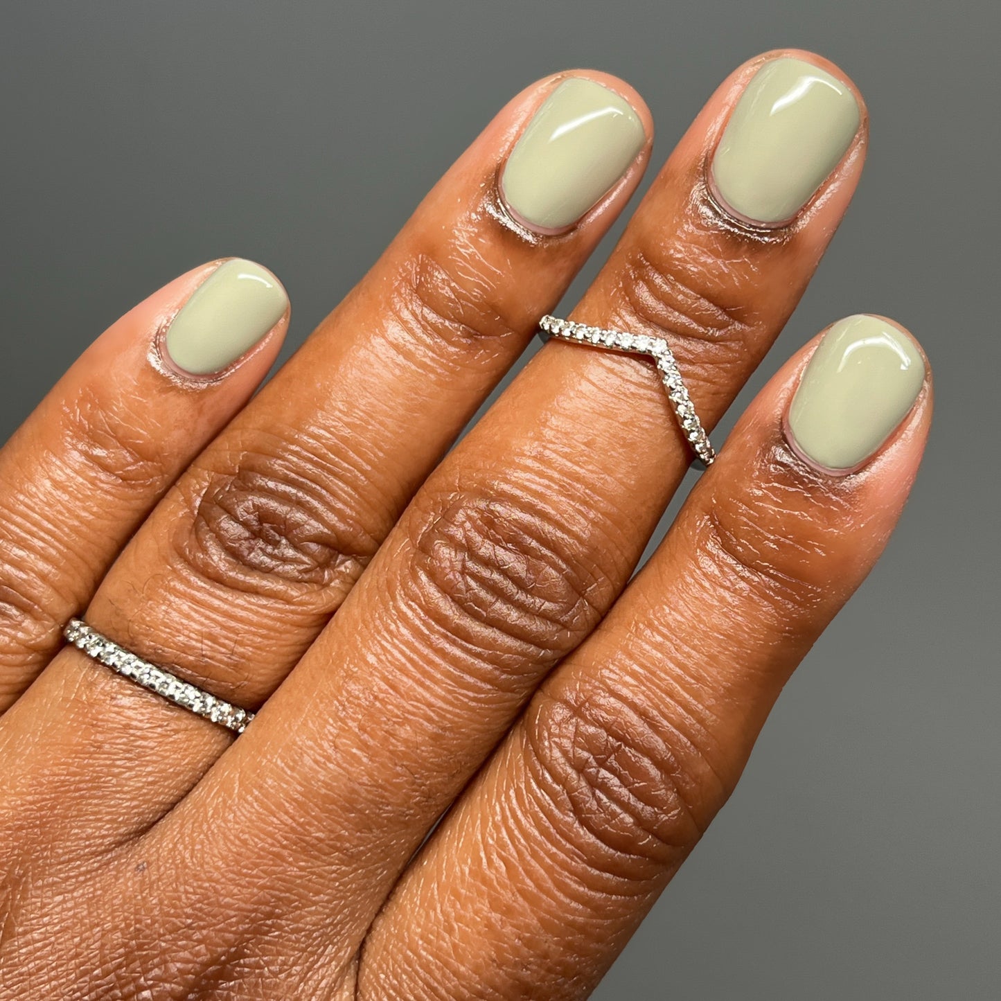 Light sage cream nail polish on dark skin