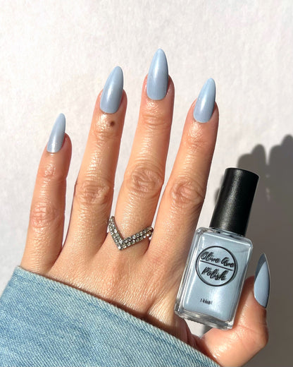 Pastel blue pearl nail polish on light skin