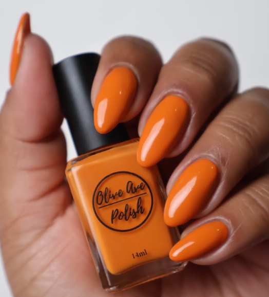 Fall orange nail polish swatch on medium dark skin tone