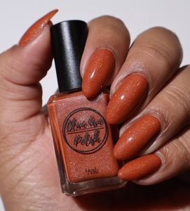 orange holographic nail polish on medium skin tone