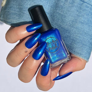 Blue glitter nail polish swatch on pale skin tone