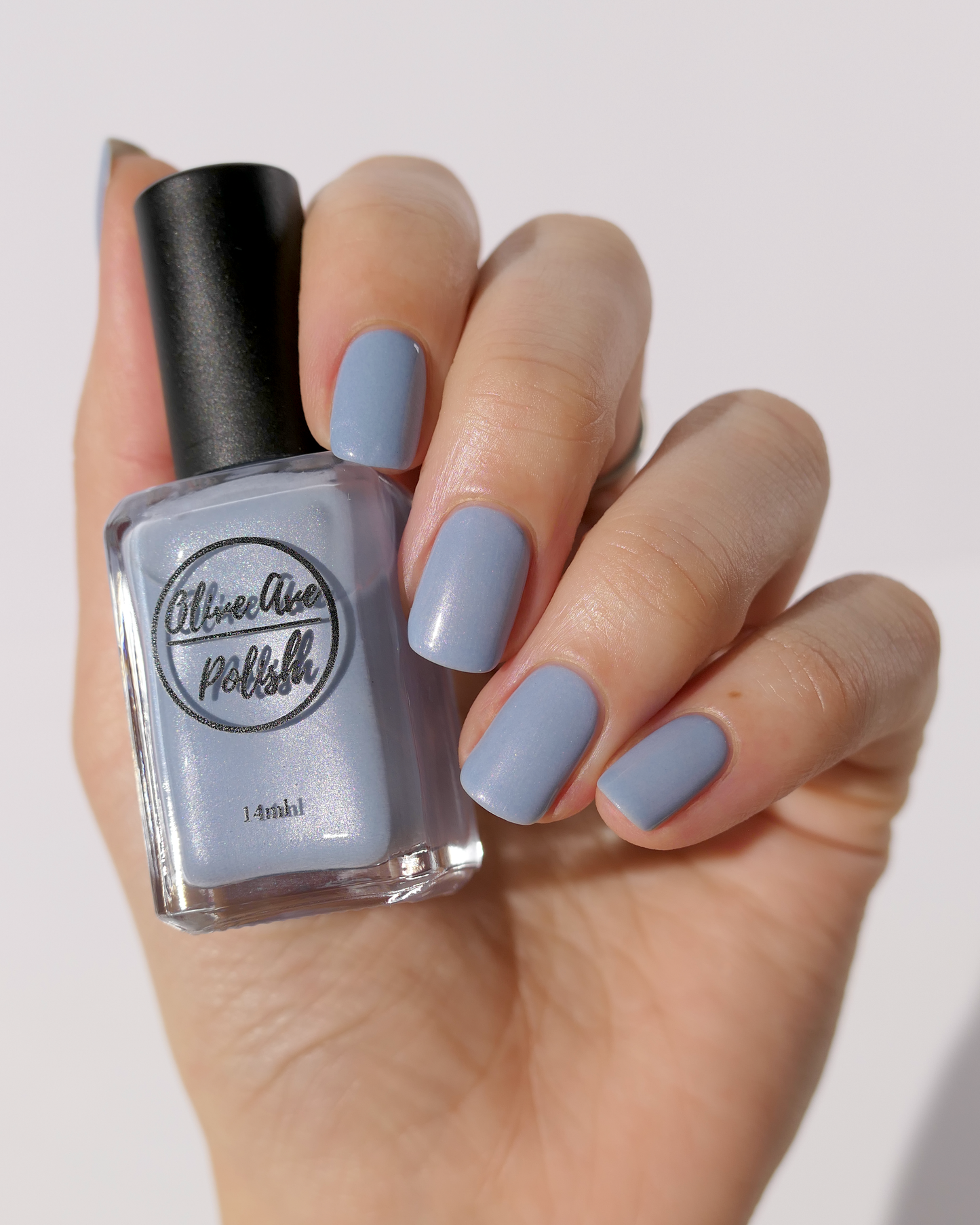 Pastel blue pearl nail polish on light skin