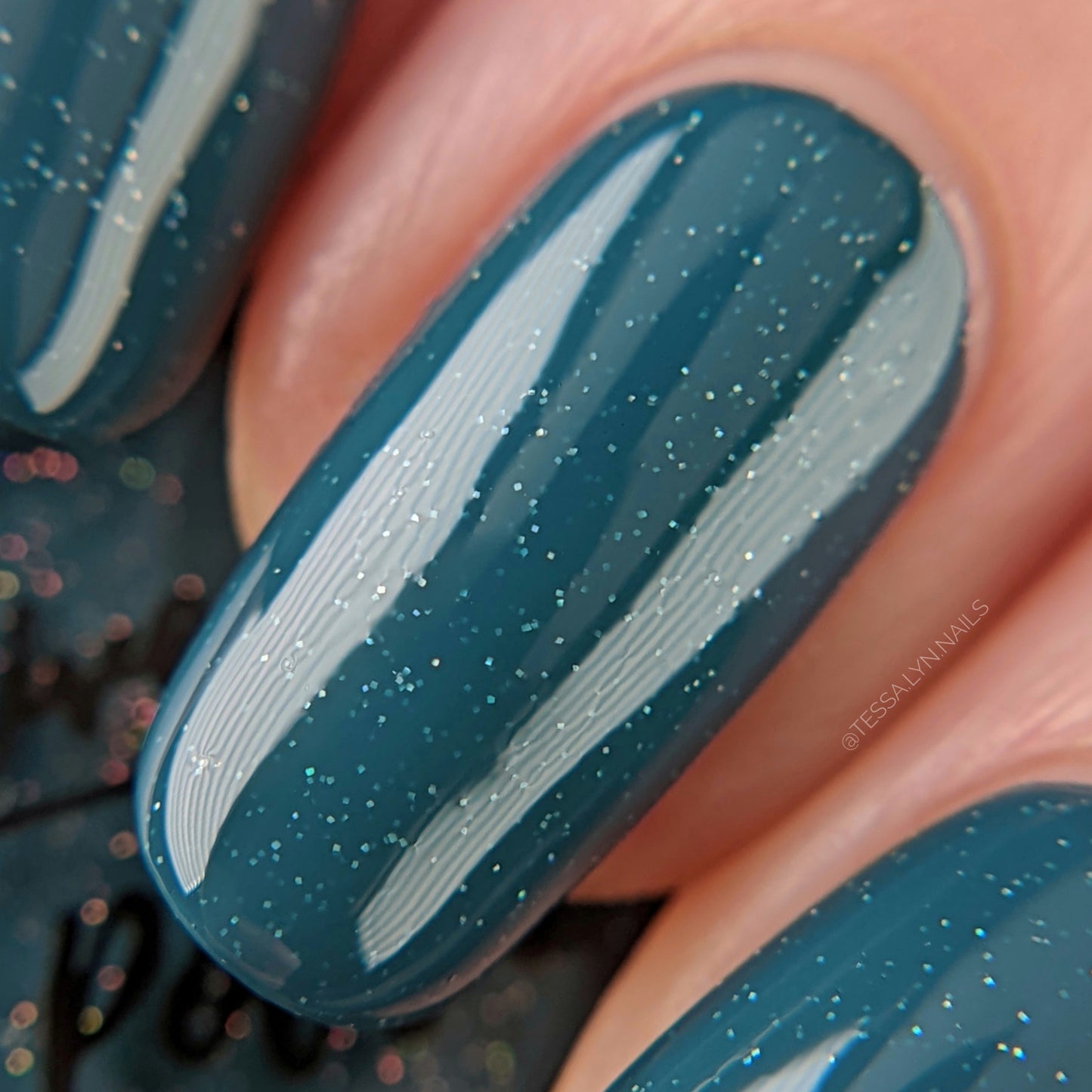 blue holographic nail polish swatch on pale skin tone