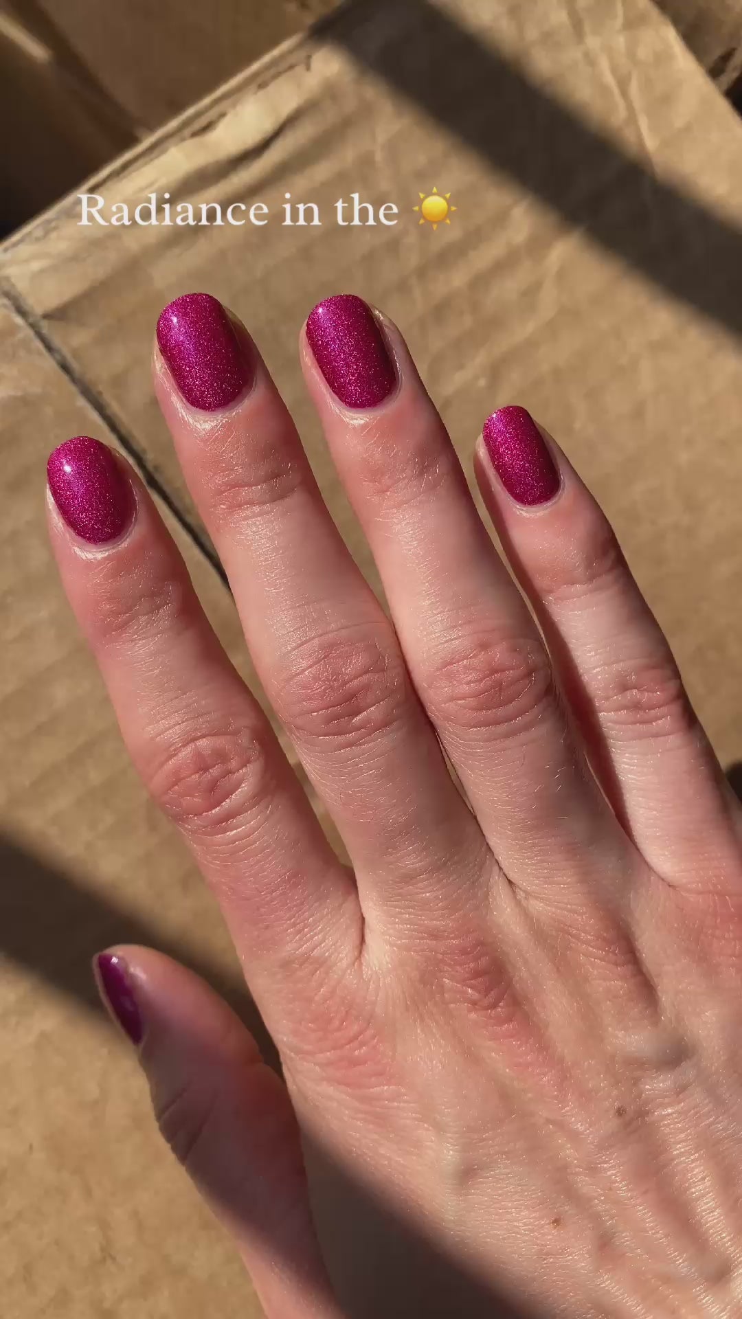 Pink holographic nail polish in sun and indoors