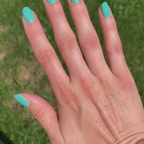 Blue green nail polish in sun and indoors