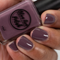 purple grey nail polish swatch on medium skin tone