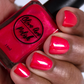 coral shimmer nail polish swatch on medium skin tone