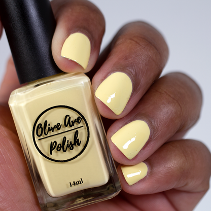 pastel yellow nail polish swatch on medium deep skin tone