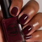 Burgundy wine nail polish swatch on medium skin tone