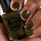 Green holographic nail polish swatch on medium dark skin tone
