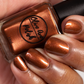 metallic brown nail polish swatch on medium skin tone