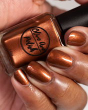Load image into Gallery viewer, metallic brown nail polish swatch on medium skin tone