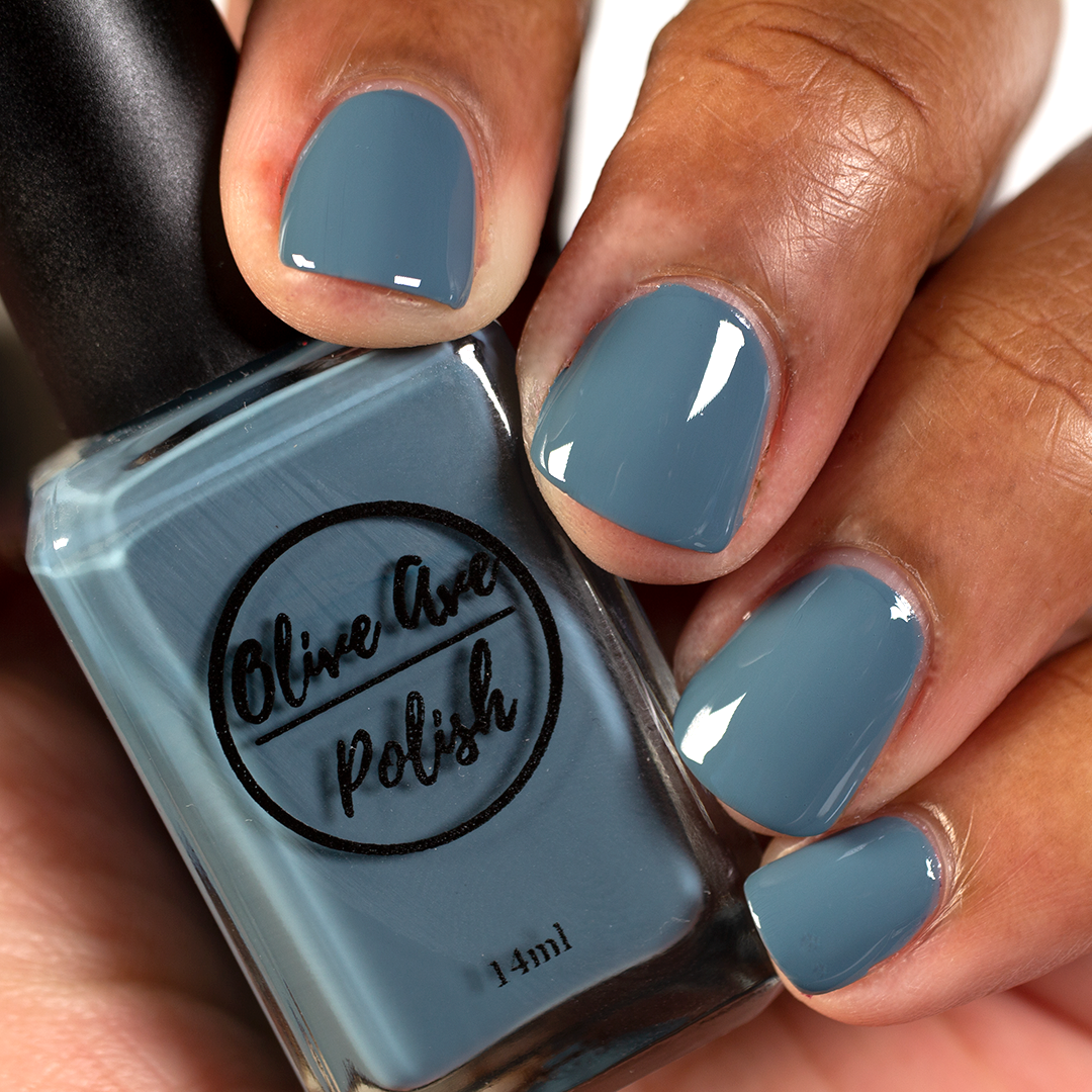 Dusty cerulean blue nail polish on medium dark skin tone