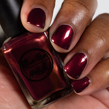 Load image into Gallery viewer, burgundy nail polish with gold shimmer swatch on medium skin tone