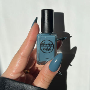 Dusty cerulean blue nail polish swatch on pale skin