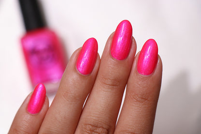 Pink glitter nail polish swatch on pale skin tone
