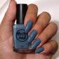 Dusty cerulean blue nail polish on medium skin tone