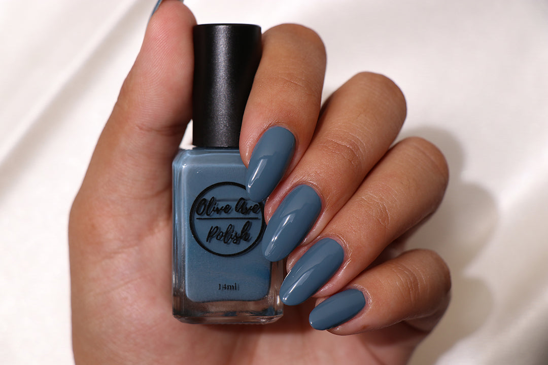Dusty cerulean blue nail polish on medium skin tone
