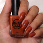 Fall orange nail polish swatch on medium skin tone