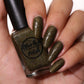 Green holographic nail polish swatch on pale skin tone