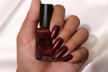 Load image into Gallery viewer, burgundy nail polish with gold shimmer swatch on pale skin tone
