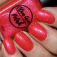 coral shimmer nail polish swatch on pale skin tone