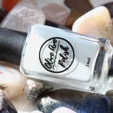 Load image into Gallery viewer, Off white nail polish bottle on rocks